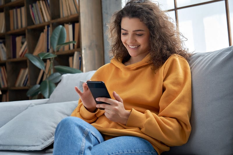 Woman scrolling her phone reading about cyber security tips.