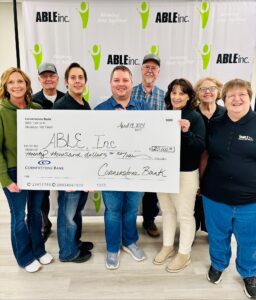 Able Inc. team holding check